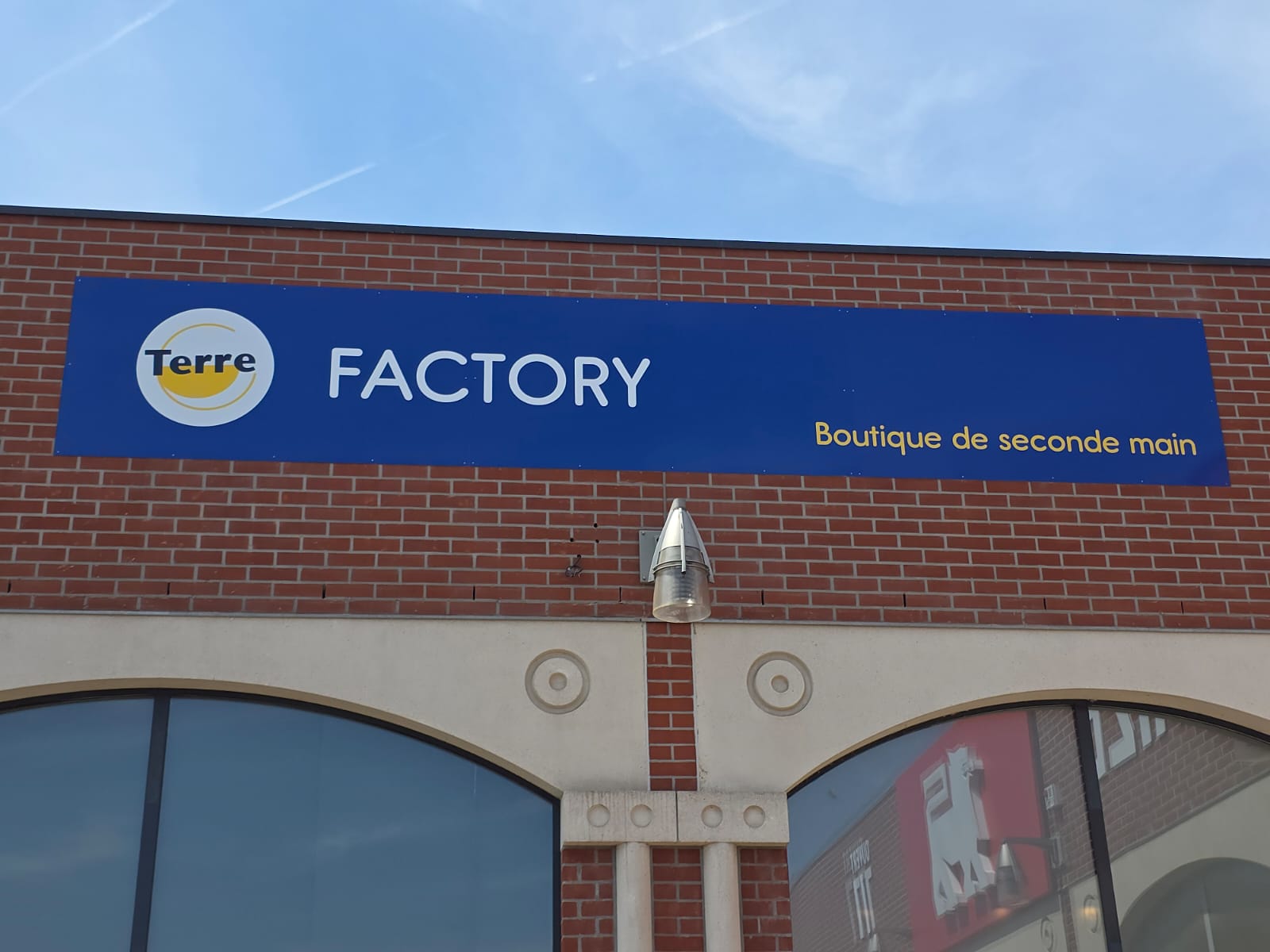 Enseigne Terre Factory boutique de seconde main sur façade de magasin
