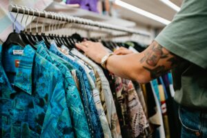 Bras d'une dame qui regarde des vêtements installés sur un portant