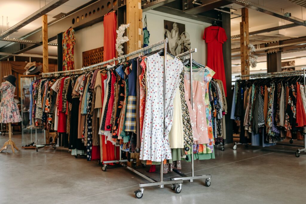 Un magasin rempli de vêtements vintages, soigneusement disposés sur des étagères et des cintres.