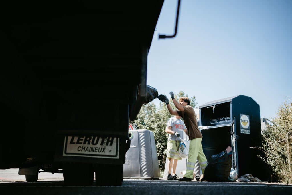 Des hommes jetent des sacs de vêtements à l'intérieur d'un camion Terre