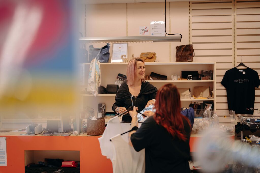 Une vendeuse dans un magasin sert une dame à la caisse.