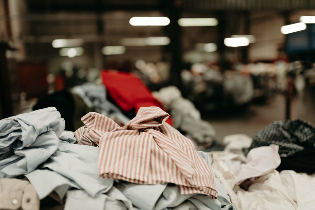 Tas de vêtements colorés dans un centre de tri