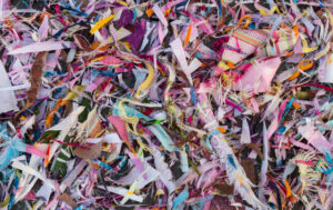 Fond, restes de fils et nombreux morceaux colorés provenant de la couture et des réparations s'entassent.